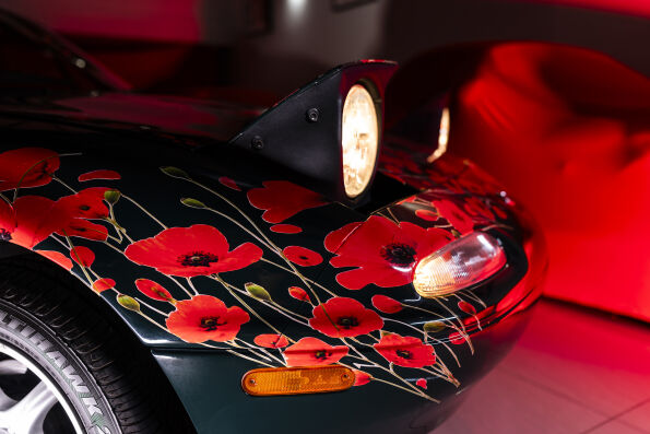 Close-up of the poppy livery on the Mk1 Mazda MX-5 front fender